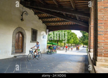 La loggia superiore di Saint Mary's Gate (Porta Santa Maria) con le persone e i turisti in bicicletta sulla strada rotonda delle mura della città di Lucca, Toscana, Italia Foto Stock