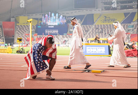 Doha, Katar. 28 Sep, 2019. Vincitore Christian Coleman (USA/1° posto) avvolto in una bandiera statunitense, dietro di lui due uomini andare in Thawb. 100m uomini finale, su 28.09.2019 mondiali di atletica 2019 a Doha/Qatar, dal 27.09. - 10.10.2019. | Utilizzo di credito in tutto il mondo: dpa/Alamy Live News Foto Stock