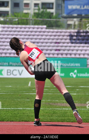 Giovane atleta femminile alla fine del suo lancio, il rilascio in una tipica posizione anteriore occhiatura suo giavellotto Foto Stock