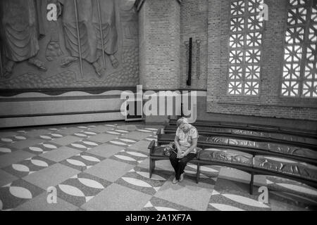 Aparecida, São Paulo, Brasile - 13 Gennaio 2016: donna brasiliana prega alla cattedrale di Nossa Senhora Aparecida Santuario Nazionale Foto Stock