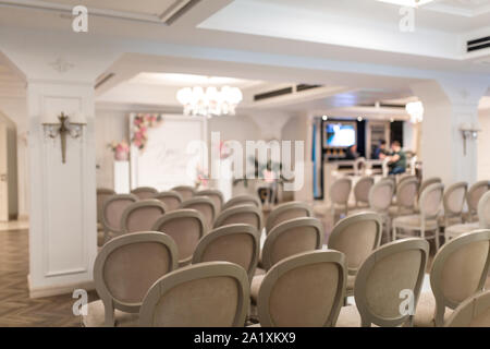 Per matrimoni. Righe di festosa bianco sedie per gli ospiti. Arco di nozze per la sposa e lo sposo Foto Stock