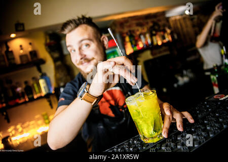 Brutolny barista uomo fa colare whiskey Foto Stock