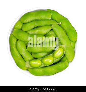 Fagioli di soia verde del pod, edamame, in bianco ciotola. Acerbi fave di soia, anche Maodou. Glycine max, un legume, commestibili dopo cottura e ricca fonte di proteine Foto Stock