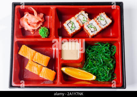 Il cibo fresco porzione in giapponese scatola di Bento con insalata, corso principale. Rotolo di Sushi con verdure. Piatto vegetariano. Foto Stock