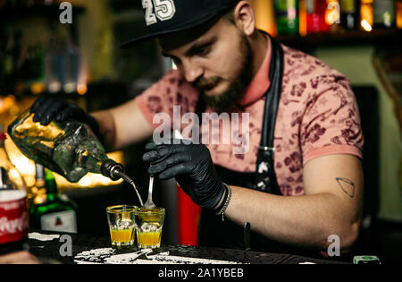 KHARKIV, Ucraina - 15 giugno 2019: Brutolny barista uomo fa colare whiskey Foto Stock