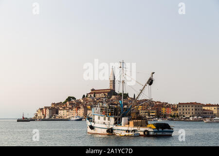 Un peschereccio è ormeggiata in parte del porto di Rovigno con la città vecchia si vede in background. Foto Stock