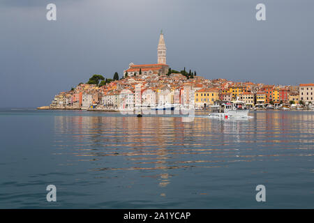 Case colorate sembrano sorgere dal mare sulla penisola collinare che ospita la città vecchia di Rovinj in Croazia. Foto Stock