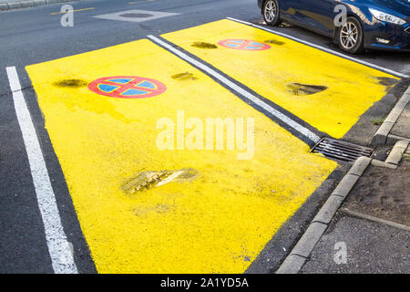 Due aree di parcheggio verniciate di giallo con spazio libero senza stop o segnale di parcheggio. Parcheggio consentito solo per i clienti del negozio Foto Stock