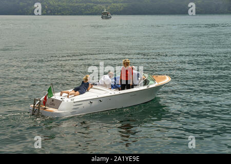 Il LAGO DI COMO, Italia - Giugno 2019: persone rilassante su un motore privato lanciare a Lenno sul Lago di Como. Foto Stock