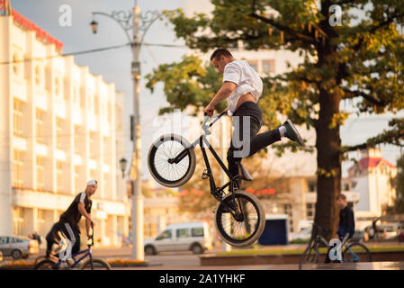 Il ragazzo esegue uno stunt sul BMX, saltando dal parapetto in alto. Foto Stock