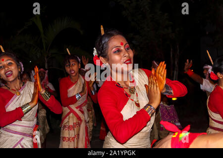 Sorridente giovani donne locali ballerini in abito tradizionale eseguire a un Indiano Nuovo Anno danza di Kaziranga, quartiere Golaghat, Bochagaon, Assam, India Foto Stock