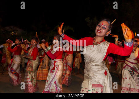 Sorridente giovani donne locali ballerini in abito tradizionale eseguire a un Indiano Nuovo Anno danza di Kaziranga, quartiere Golaghat, Bochagaon, Assam, India Foto Stock