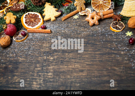 Sfondo di natale con albero di Natale ramo, festosa decorazione, frutta secca, i biscotti fatti in casa e tradizionali spezie stagionali Foto Stock