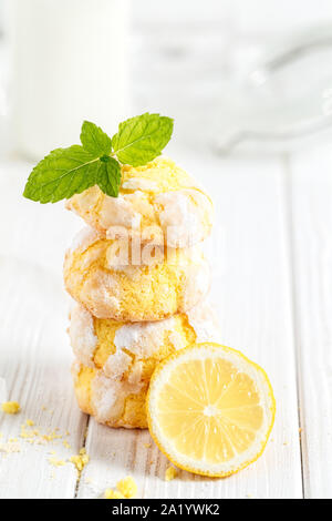 Pila di limone incrinato i cookie su un bianco sullo sfondo di legno. Composizione verticale Foto Stock