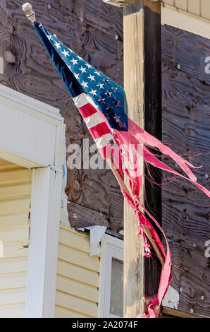 Un strappata bandiera americana pende da un condominio danneggiato dall' uragano Michael in 2018, Sett. 27, 2019, in Messico Beach, Florida. Foto Stock