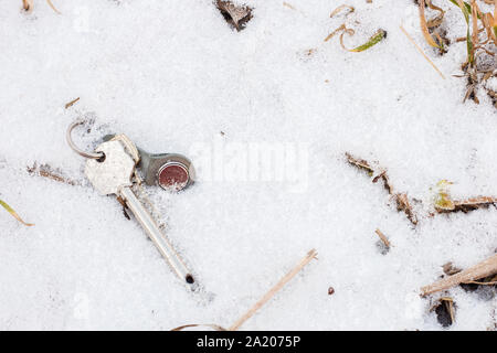 Set di chiavi che giace sulla neve in inverno Foto Stock