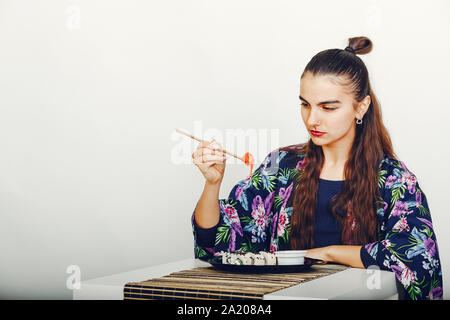 Bella ragazza di mangiare un sushi in un studio Foto Stock