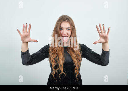Ragazza dai capelli marrone in abito nero isolato su sfondo bianco mostra emozioni Foto Stock