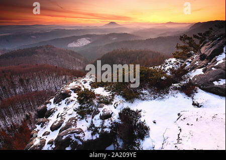 Molla blu lo spuntar del giorno, lo scongelamento di ultima neve. Scogliera di arenaria al di sopra di una profonda valle nebbiosa. Foto Stock