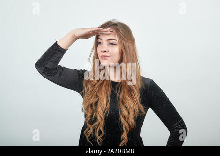 Ragazza dai capelli marrone in abito nero isolato su sfondo bianco mostra emozioni Foto Stock