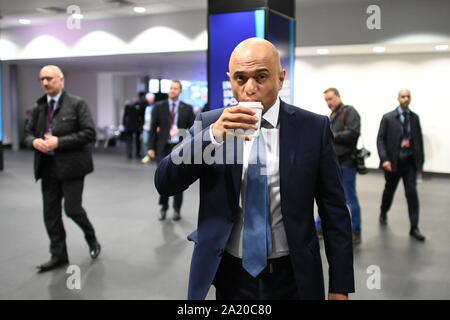 Il cancelliere Sajid Javid sorseggia un drink prima della prima sessione della giornata presso il congresso del partito conservatore al Manchester Convention Center. Foto Stock