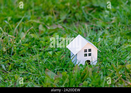 Giocattolo di legno casa su uno sfondo di erba verde. Eco-friendly house. Il concetto di una casa di campagna. Copia dello spazio. Foto Stock