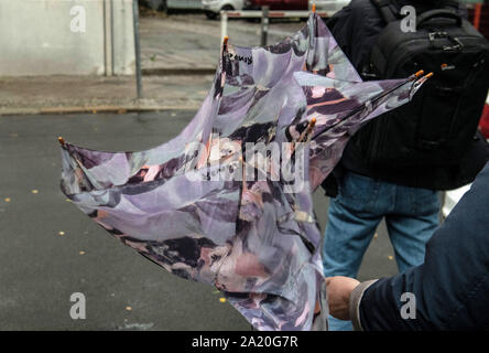 Berlino, Germania. Il 30 settembre, 2019. Una donna lotte con il suo ombrello, che è stata piegata da un forte colpo di vento. Credito: Paolo Zinken/dpa/Alamy Live News Foto Stock