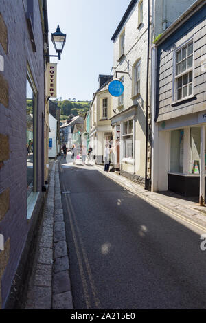 Gli amanti dello shopping a piedi verso il basso Fore Street nella città costiera di Mevagissey in Cornovaglia il villaggio è noto per le sue strette strade e vicoli Foto Stock