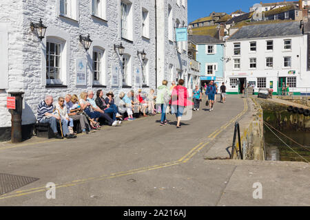Turisti che si siedono al di fuori del ristorante Sharksfin godendo della tarda estate sole nella città costiera di Mevagissey Cornovaglia Foto Stock