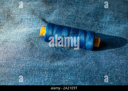 Rocchetto di filo su un jeans blu con una testa rotonda pin messo nello stelo, la foto è stata scattata in Paesi Bassi Foto Stock