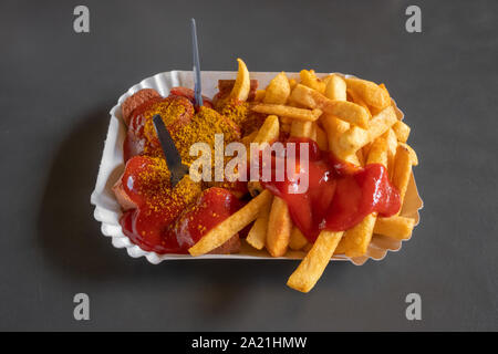 Currywurst con patatine fritte su un piatto di carta Foto Stock