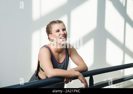 Giovane donna in boxer trecce formazione nel contesto urbano, indossare abbigliamento sportivo con neon sport bra. Foto Stock