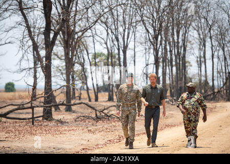 Il Duca di Sussex, con il Brigadiere Tom Bateman (sinistra), arriva al memoriale per Guardsman Mathew Talbot delle guardie Coldstream al Liwonde parco nazionale in Malawi, il giorno otto del royal tour di Africa. Foto Stock