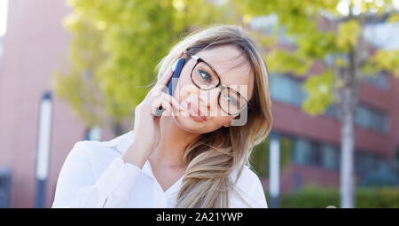 Giovane donna got complimento chiamata mentre chiamando all'aperto Foto Stock