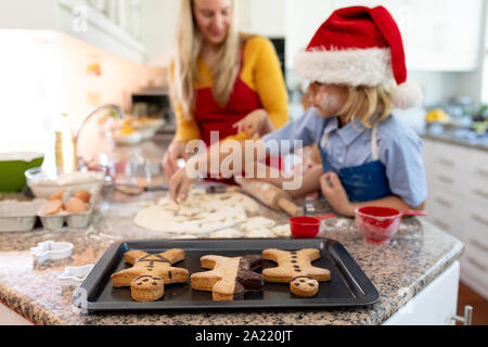 Famiglia rendendo biscotti di Natale a casa Foto Stock