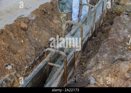 Confina con il concreto processo di installazione marciapiede marciapiede rinnovamento di fissaggio bordi stradali sul sito in costruzione Foto Stock