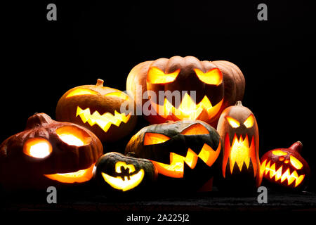 Foto di zucche di Halloween con bocche di masterizzazione in bianco su sfondo nero in studio Foto Stock