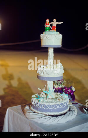 Torta nuziale sulla spiaggia. Matrimonio nel concetto tropico Foto Stock