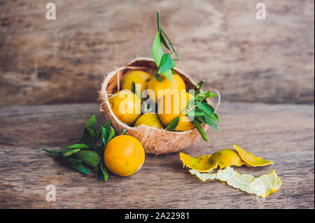 Tangerini freschi con foglie sul vecchio sfondo di legno Foto Stock