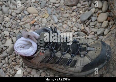 Una scarpa e calzini vicino al fiume Foto Stock