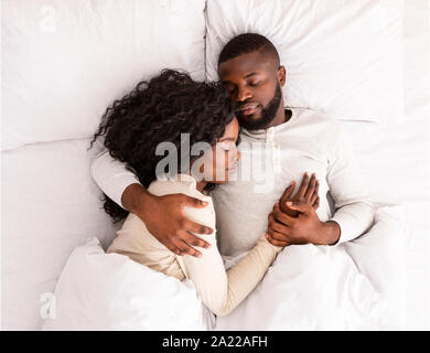 Giovane americano africano giovane dormire insieme nel letto, abbracciando ogni altra vista superiore Foto Stock