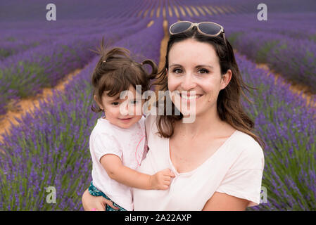 Madre e figlia a passeggio tra i campi di lavanda in estate Foto Stock