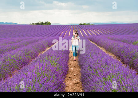 Madre e figlia a passeggio tra i campi di lavanda in estate Foto Stock