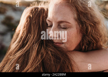 Close up dettaglio della madre faccia mentre abbracciando la figlia in spiaggia