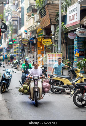 Uomo sulla motocicletta drive alla vecchia di Hanoi, Vietnam. Scena tradizionale da Hanoi street. Foto Stock