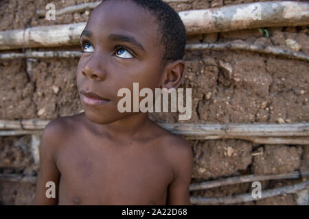 Ragazzo afro-brasiliana cercando su una argilla casa sullo sfondo Foto Stock