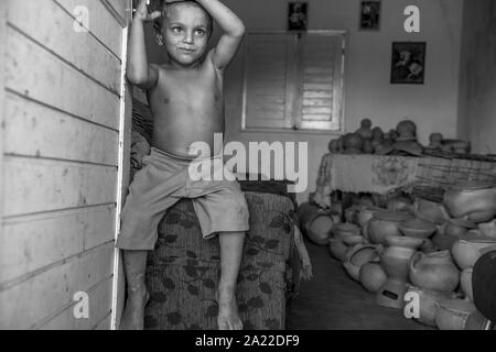 Ragazzo seduto sul lettino al quilombo Muquem Foto Stock