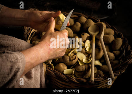 Renaissance master precedente ritratto di mani femminili sbucciare le patate in un caminetto Foto Stock