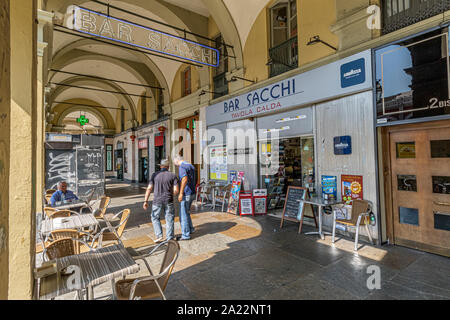 Due uomini avente una discussione al di fuori dei bar Sacchi sotto il colonnato gallerie dello shopping lungo Via Sacchi , Torino , Italia Foto Stock