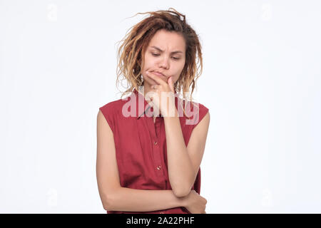 Giovane donna asiatica con dreadlocks accigliata la sua faccia avendo dubbi e sospetti sensazione. Essendo scettico circa qualcosa. Studio shot Foto Stock